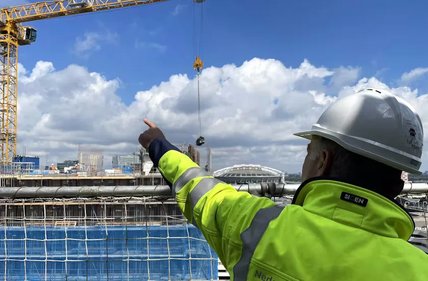 Inspecteur Leo van der Sanden wijst naar een van de torenkranen. Foto: Cobouw.